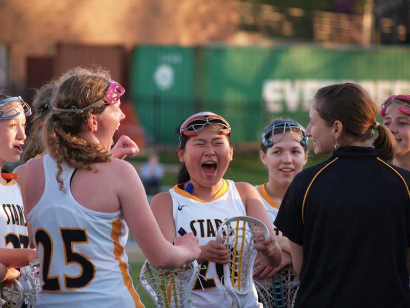 Sophomore Molly Wollery, center, and the rest of the JV lacrosse game celebrates their first game of the season, beating Notre Dame de Sion, 14 - 3 last Friday at STA. Sophomore Katie Tampke, a member of the JV team, said, Its always exciting when you play the first game of the season and you win. It gives your team the confidence you need to play the rest of the season. (Libby Hyde)