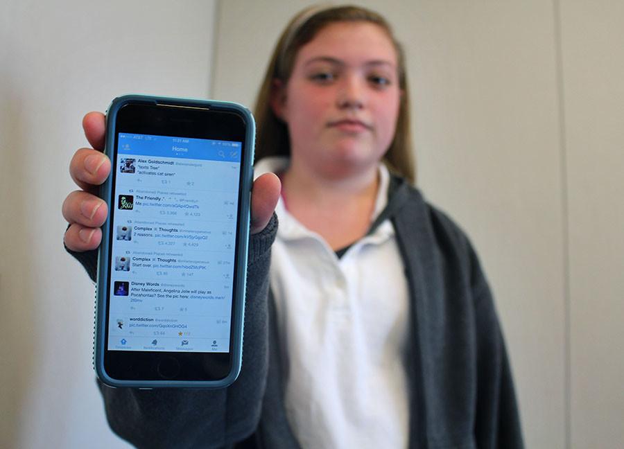 Sophomore Sarah Cozad holds up her phone displaying her Twitter feed. Cozad was recently a target of a fake twitter account which has changed her views on how she perceives social media.