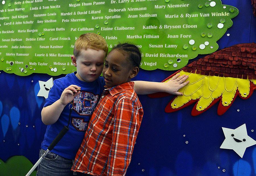Six-year-old Brad McCartney, left, touches a wing on a mural behind six-year-old Arion Jones at the Children’s Center for the Visually Impaired (CCVI) March 28, 2014. CCVI aims to heighten its students other senses by using feel objects. photo courtesy of MCT Campus
