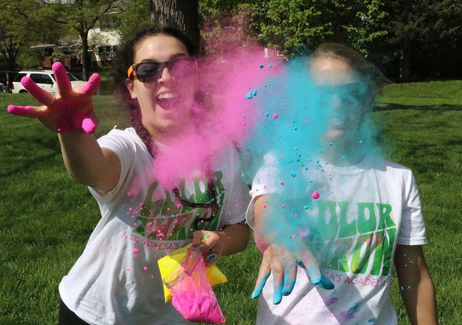 Seniors Sophia Hall, left, and Carson Beineman start the Color Throw April 27. Seniors began the event by throwing color on underclassmen on the southwest lawn directly after the Walk of Fame. photo by Hannah Bredar