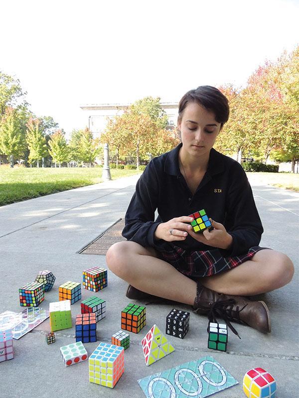 Junior Emma Gustavson solves a Rubiks Cube on the quad Oct. 6. Gustavson competes in timed competitions to solve the Rubiks Cube. photo by Maddy Medina