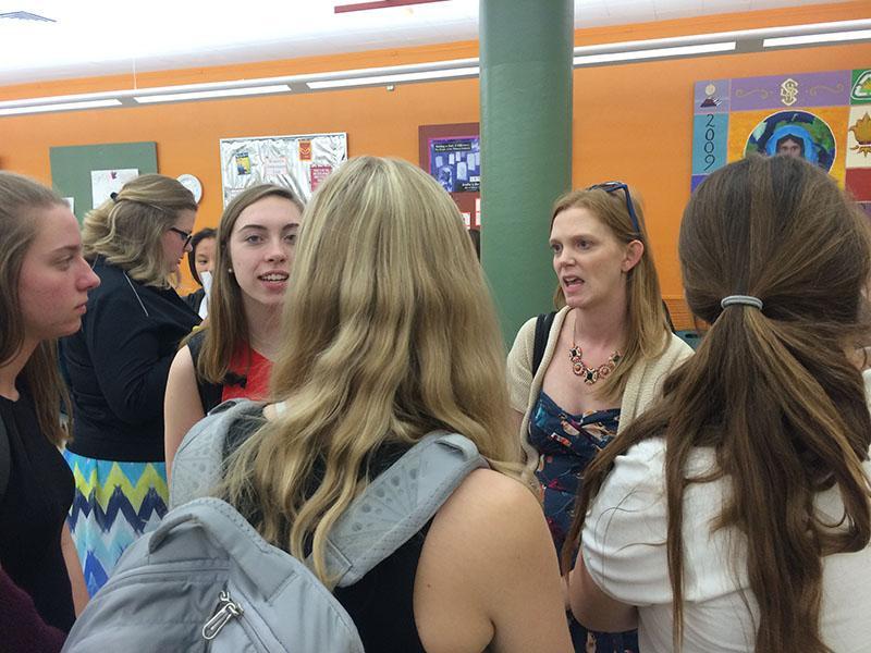 Debate coach Kate Absher, right, speaks with STA debate team members after their first competition Sept. 30. photo by Helen Wheatley