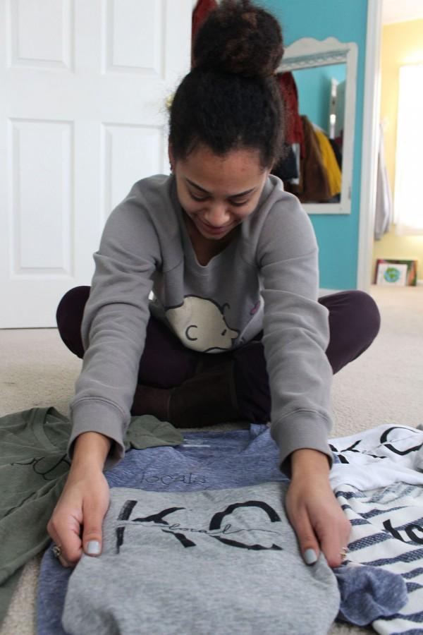 Senior Jewell Allen folds her t-shirts. Allen designs and sells these shirts with her sister. photo by Kat Mediavilla