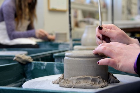 Senior Jaclyn Blanck puts some finishing touches on her ceramics pot during her Ceramics 1 class period Feb. 19. photo by Alex Davis