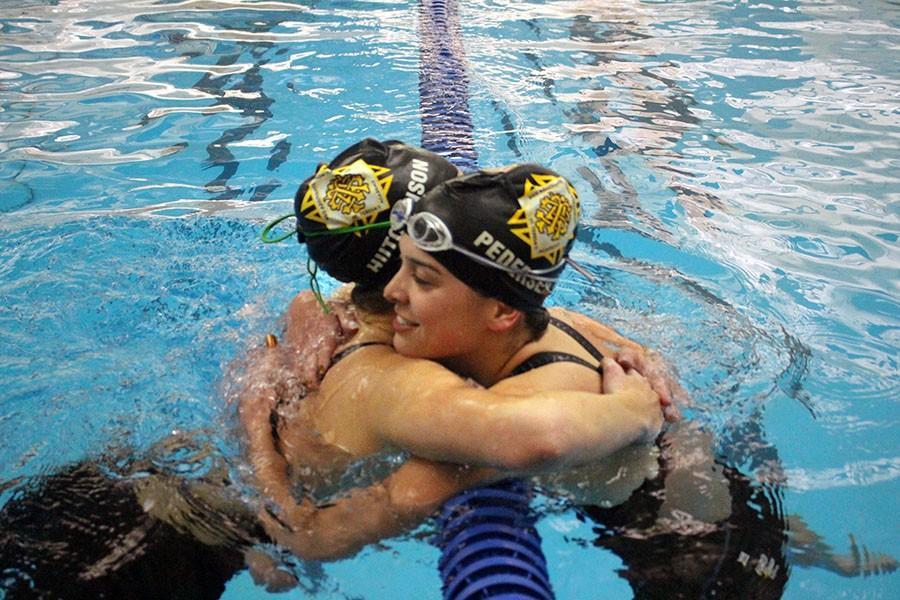Junior Libby Hutchinson, left, hugs senior Darby Pedersen after getting her State cut in the 200 yard freestyle. Hutchinson won the event and Pedersen finished third.
