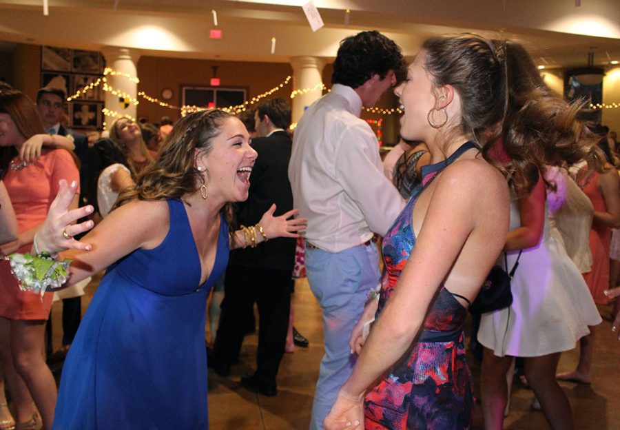 Juniors Jamie Hafenstine, left, and Meggie Mayer greet each other after arriving at the Junior Ring dance April 9. photo by Kat Mediavilla