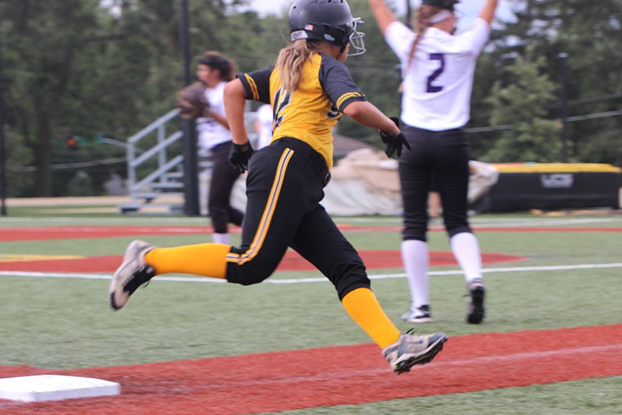 Junior Gabby Pesek sprints from third to home base in hopes of scoring a point for STA The final score for the vasrity softball game was 10-2. photo by Anna Louise Sih