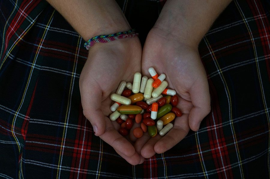 An+STA+student+holds+a+handful+of+pills.+photo+by+Gabby+Martinez