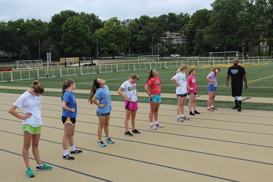 Coach Steve Redmond, far right, leads the girls in the 8-week conditioning program in stretches between each workout. photo by Anna Louise Sih