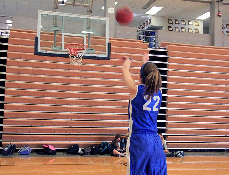 Junior Natalie Kistler shoots a freethrow to warm up for her team’s first CYO basketball practice Nov. 30 in Goppert. The team practiced in preparation for their first game Saturday, Dec. 3.  photo by Sophie Sakoulas