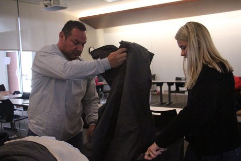 Mark Trujillo, left, puts coats into a bag as Social Justice Club Co-president Regan Reda holds the bag open at the STA Coat Drive Dec. 3. The Coat Drive broke a Guinness World Record from collecting 2,631 coats. photo by Sophie Sakoulas
