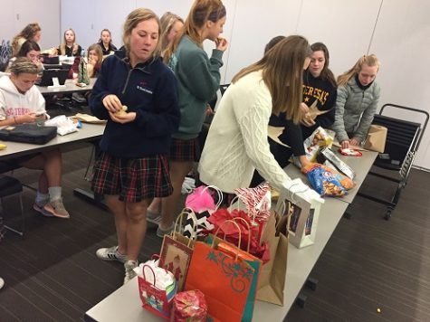 FBLA members crowd around a table which secret santa gifts. photo by Catherine Ebbits