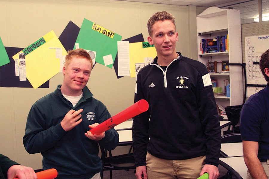 Archbishop OHara freshman Pete Whittaker, FIRE student, and senior Ryan Rieger prepare to perform a song with boomwhackers. Rieger assists students in a variety of ways at OHara, his main job being assisting FIRE students in learning to drive using golf carts. photo by Cassie Hayes
