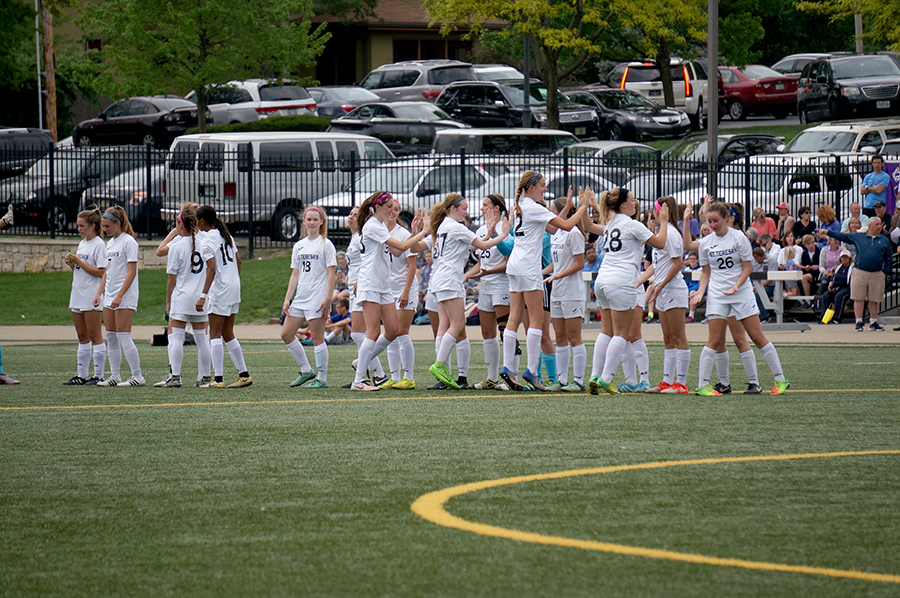 Varsity players high five each other before their soccer game. The varsity team played against Notre Dame de Sion High School April 25. photo by Gabby Martinez
