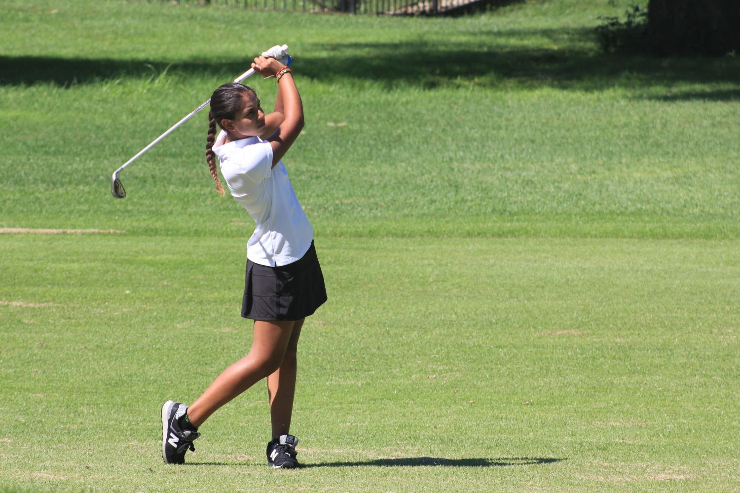 Sophomore Grace Gaume looks towards the ball after hitting it. Gaume scored an individual score of 39. photo by Zoe Butler
