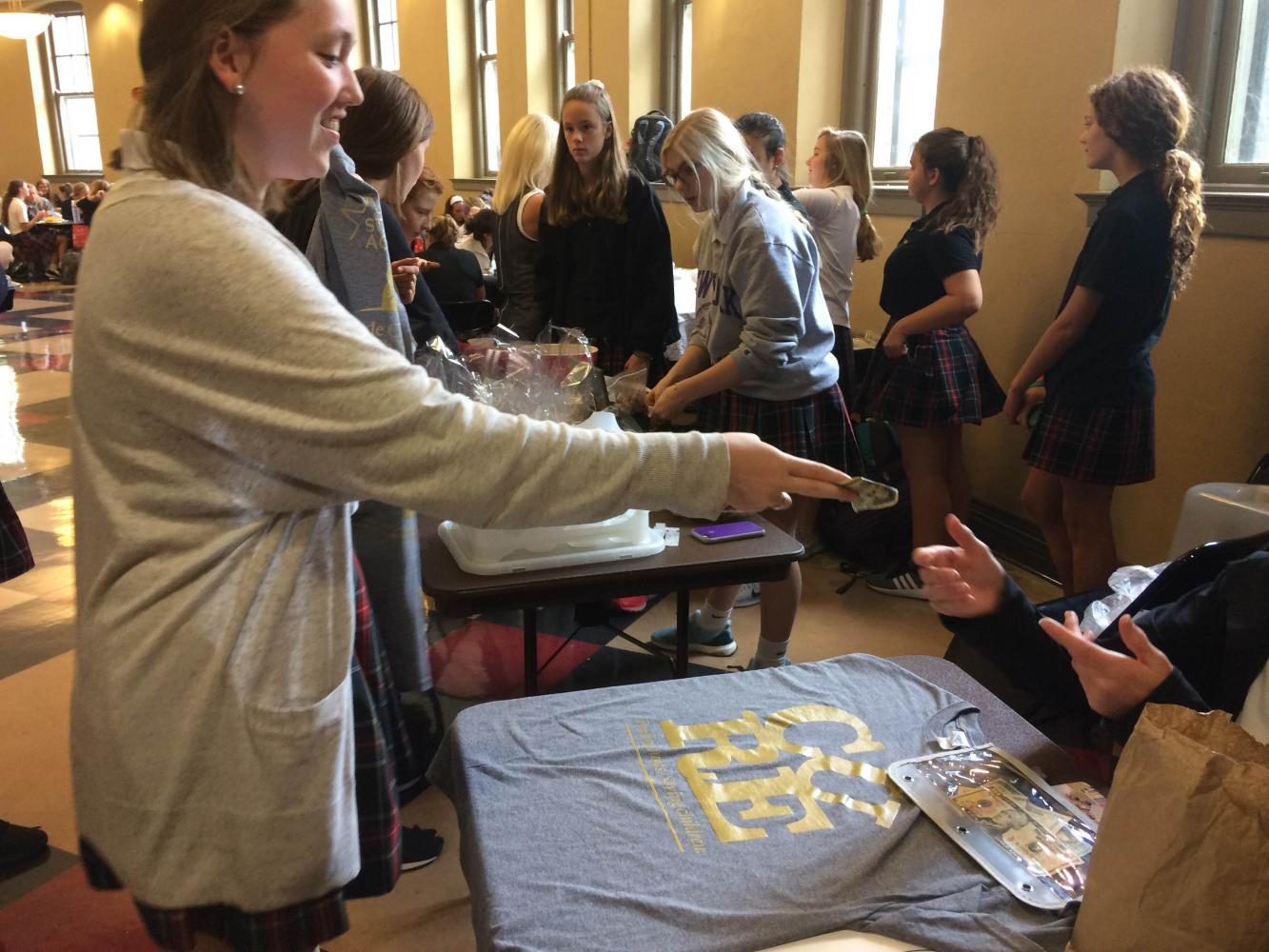 Junior Mo Burns pays money for a Team Up For St. Judes shirt. Sales to support both suicide prevention and cancer research were held in the commons Sept. 12.