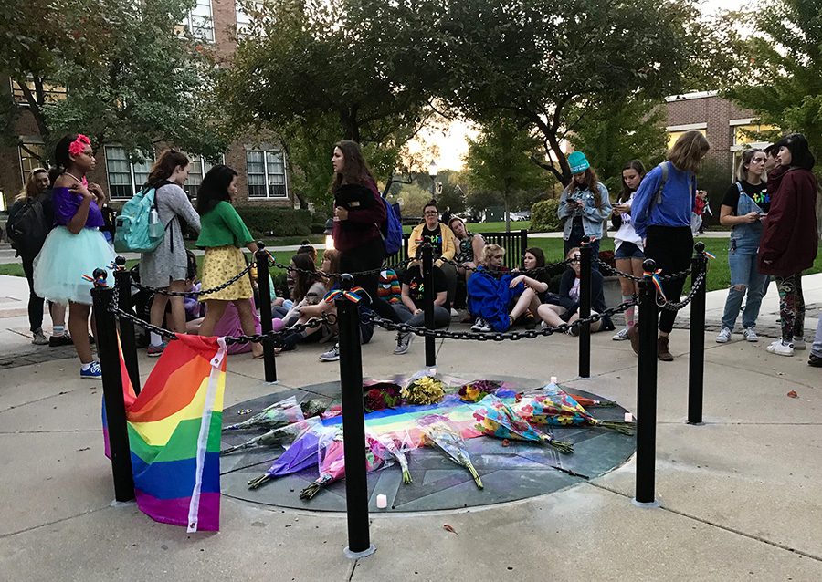 Students gather around the quad, decorated with glitter, flowers and LGBTQ pride flags in remembrance of Steven Karlin who passed away one year ago Oct. 20. photo by Lucy Hoop
