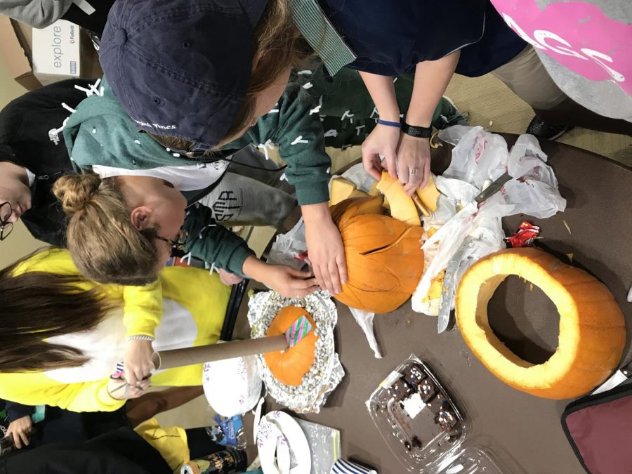 Senior, Lily Manning (left) helps senior Riley McNett carve a pumpkin