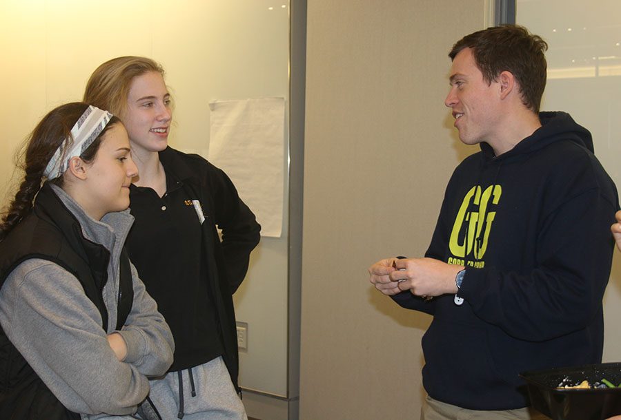 Sophomores Demi Spini, from left, and Elise McGhie talk with Mr. Boland at the Electives Fair in Windmoor Jan 10. Boland has taught Theology and Film as an elective for one year. photo by Torri Henry