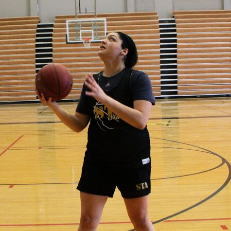 Senior Hailey Coleman looks up before she shoots a layup before practice Jan. 30. Coleman begins each practice with a shoot around followed by stretches. photo by Meghan Baker