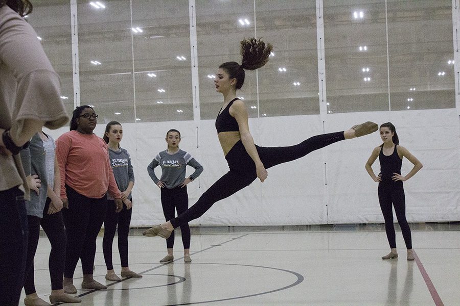 Junior Caroline Reid demonstrates a leap as her teammates watch on at William Jewell College Feb. 3. The JV dance team practiced their power jumps one-by-one before performing their routine for three technical judges. photo by Amy Schaffer