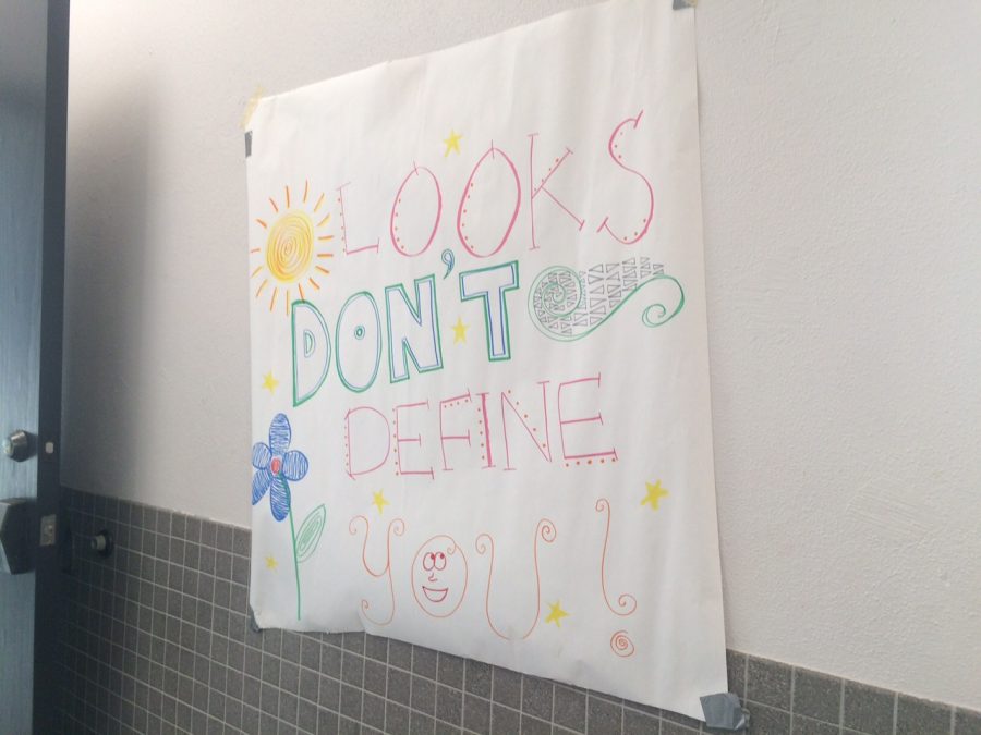 A sign in the second floor bathroom of the Music and Arts building reads looks dont define you Monday Mar. 5, 2018. Signs similar to this were hung over mirrors in bathrooms on campus. 