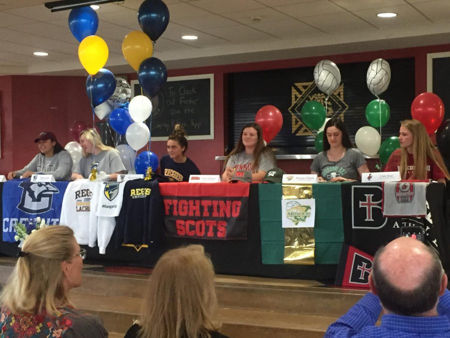 Seniors sit at their perspective tables decorated with apparel and banners of their college April 12. The seniors signed their intent letters to play in collegiate sports the following school year. photo by Anna Ronan