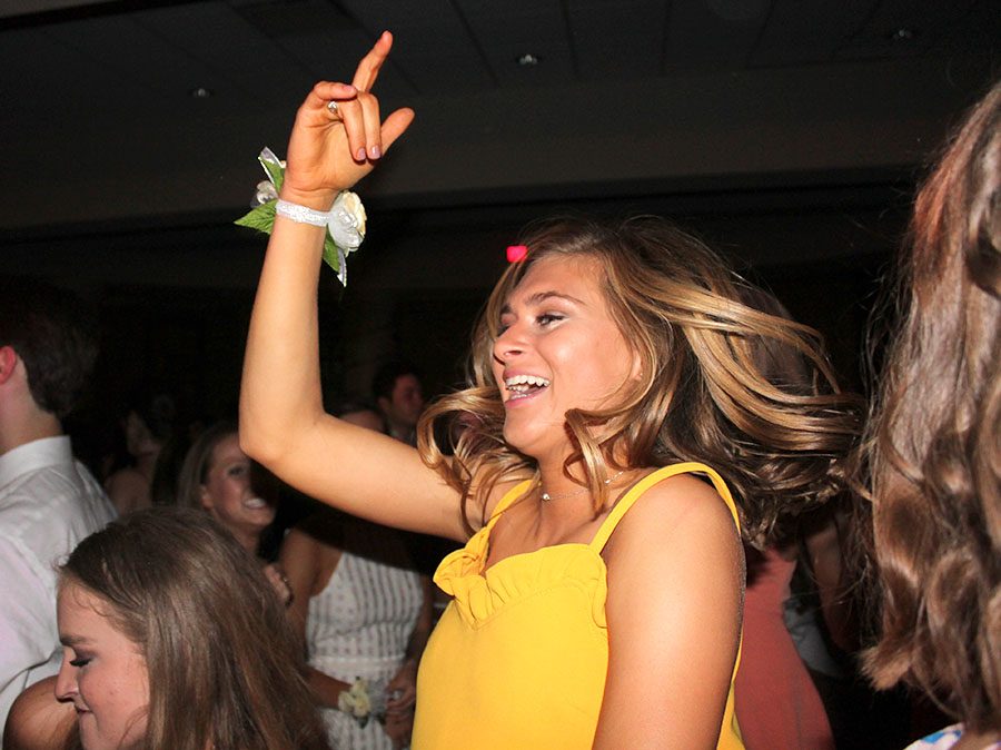 Junior Lily Farkas throws one hand in the air as she dances during the Junior Ring dance at St. Teresa’s Academy April 14. The dance was held in the Commons. photo by Meghan Baker