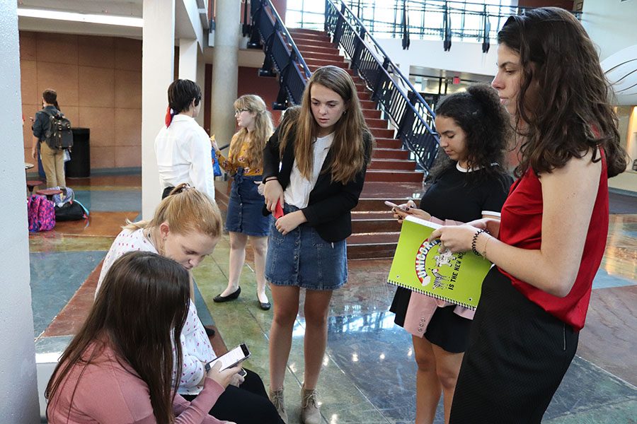 A group of students discusses the second round of debate with coach Kate Absher at Rockhurst on Sept. 19. This was the first debate this year. photo by Carmon Baker