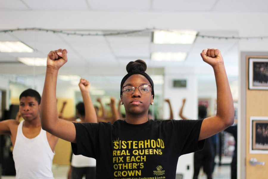 Student Laila Atkins holds up two fists, following her dance instructor’s commands Nov. 10. The series of commands walked students through arm, core and leg movements. photo by Amy Schaffer