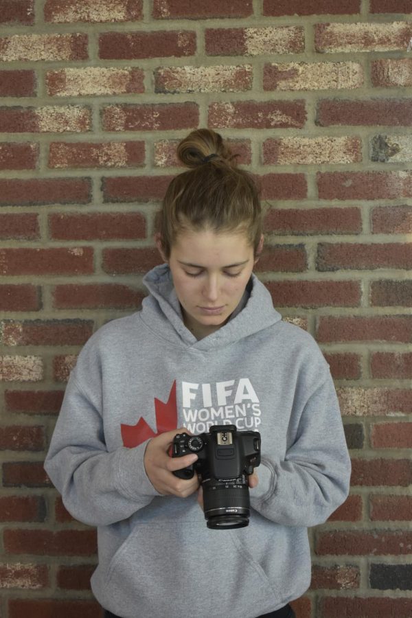 Junior Caroline Scofield, looks at the pictures she has taken on her camera. Scofield takes photos for the Truman social media. photo by Kendall Lanier 