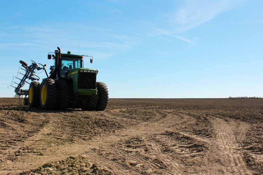 Richard Budke’s tractor sits in a field after the wet winter April 19. The “terraces” to drain rainwater and melted snow out of the field were damaged, costing Budke $15,000 to repair.