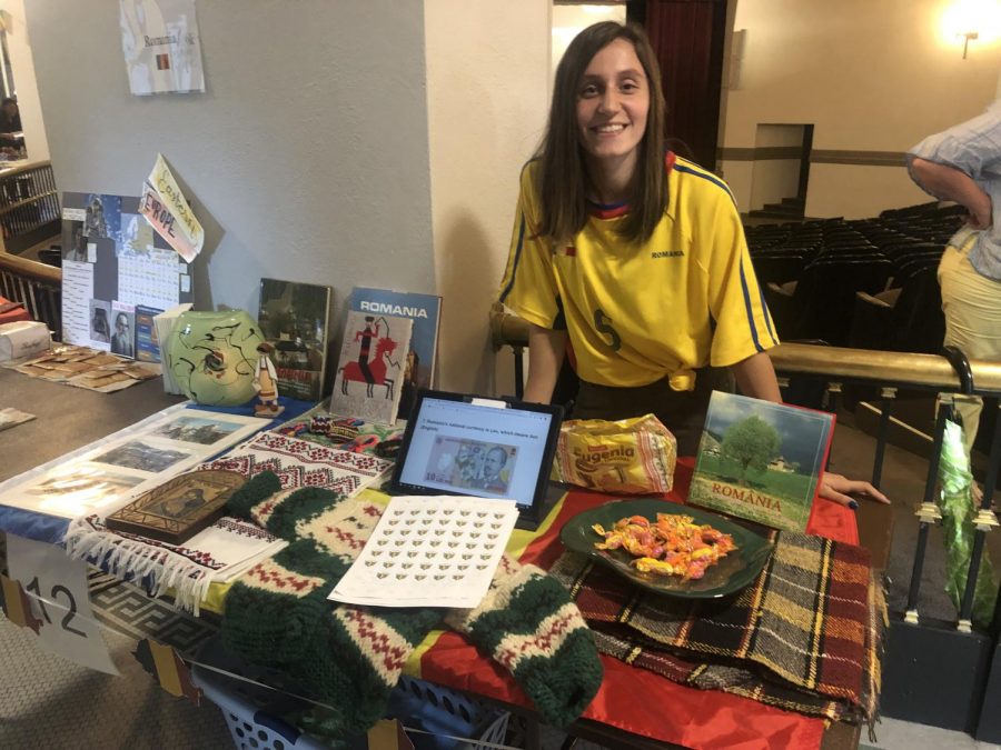 Senior Denisia Pintilie poses with her booth, representing Romania, at International Day Sept. 26. photo by Sophia Durone