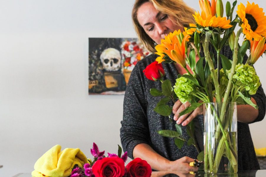 Ad Astra co-owner Sydney Gasper trims the stem off of rose to add to a floral arrangement.