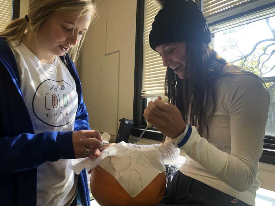 Senior Cece Wacht and senior Lauren Scofield work together to carve a pumpkin Oct. 31. Scofield and Wacht are members of the Perry advisory. photo by Becca Speier 