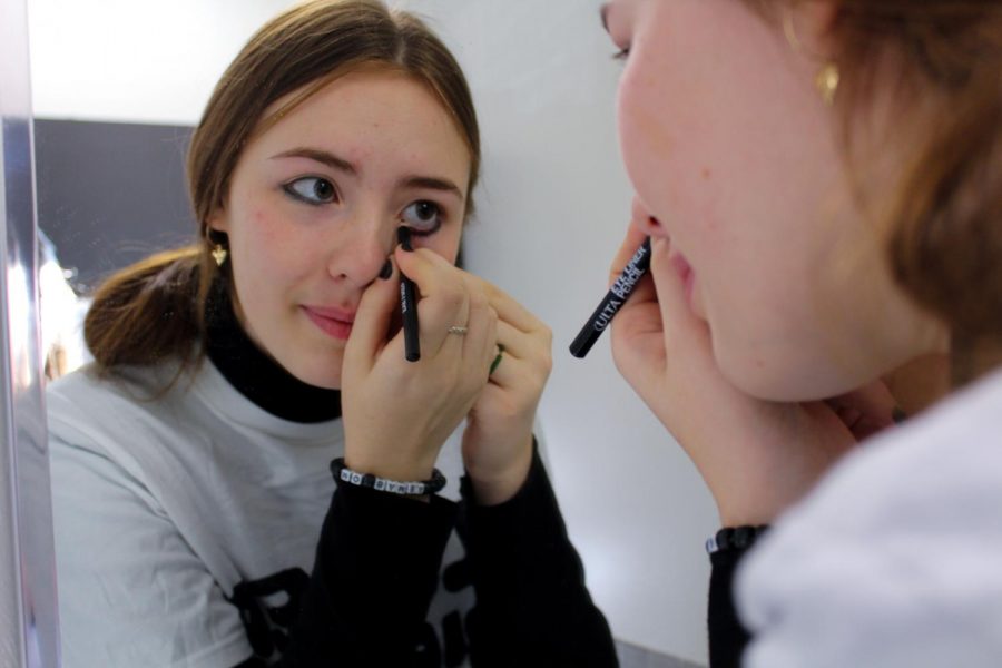 Sophomore Brighid Raymer puts on eyeliner Oct. 31. Her costume was inspired by  e-boy, Rodick Heffely, from the Diary of a Wimpy Kid. photo by Sydney Waldron
