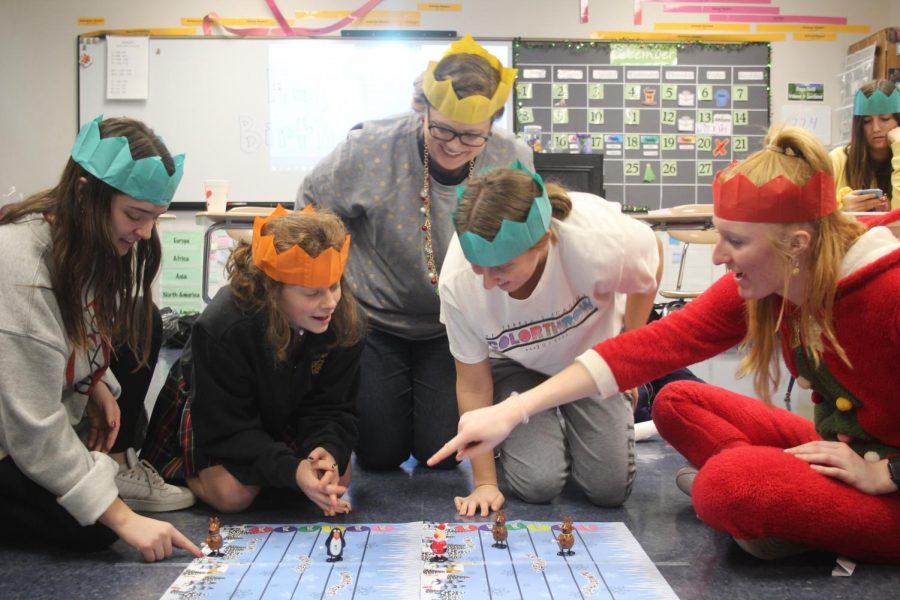Social studies teacher Alicia Stewart and four of her advisees wear paper crowns while competing in a game Dec. 13. The game and crowns were in their Christmas crackers, a tradition in the Stewart advisory. photo by Katie Massman