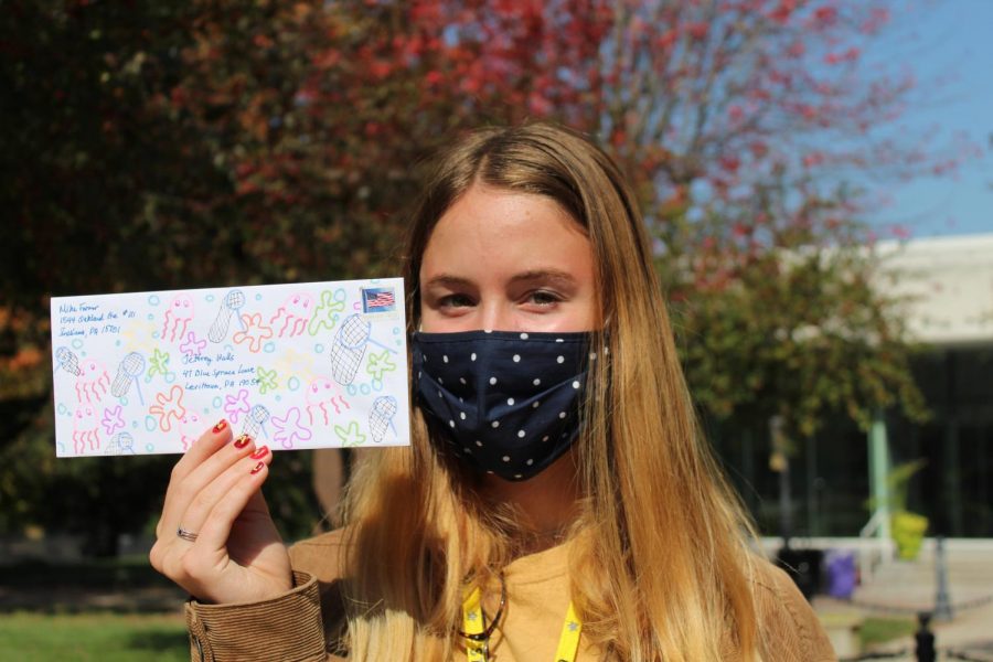Senior Abby Farmer holds up a decorated envelope containing a letter to prospective voters Oct. 7. Farmer writes letters to important swing states to try and get more people to vote democratic. photo by Katie Massman