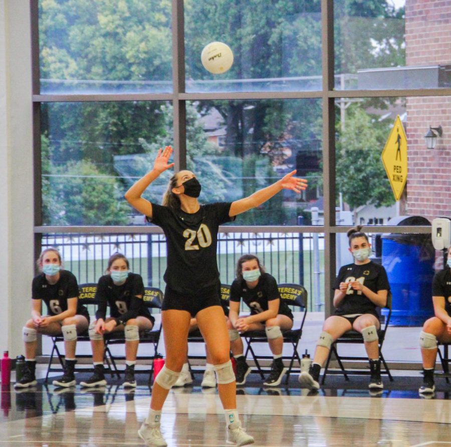 Sophomore Reagan Fox prepares to serve against Bishop Miege High School Sept. 23. Fox has been on varsity since her freshman year, and is an outside hitter. photo by Becca Speier