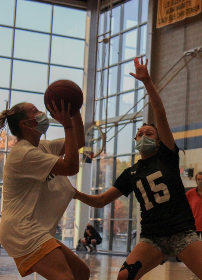 Senior Kate Gibson, left, shooting against junior Grace Quinn at basketball tryouts Oct. 5. Basketball tryouts were held over a five day period of time, and teams were finalized on the fifth day. photo by Sydney Allen