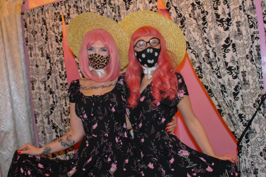 Two workers at Vetro Vixen, a retro themed store on 39th street, wear pink wigs and dresses in preparation for the holiday Jan. 28. Pink is thought to have a calming effect, and one shade known as drunk-tank pink is sometimes used in prisons to calm inmates. photo by Sydney Waldron
