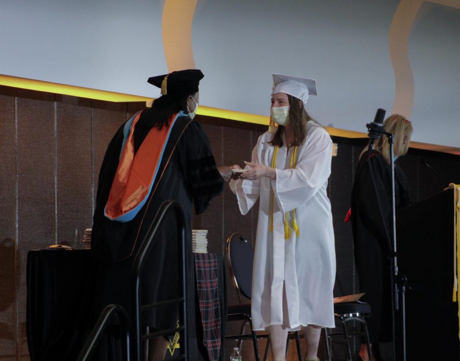 Senior Eileen Harrington crosses the stage to accept her diploma from school president Siabhan May-Washington May 15. Graduation took place in the Kansas City Convention Center. photo by Ellie Buttell