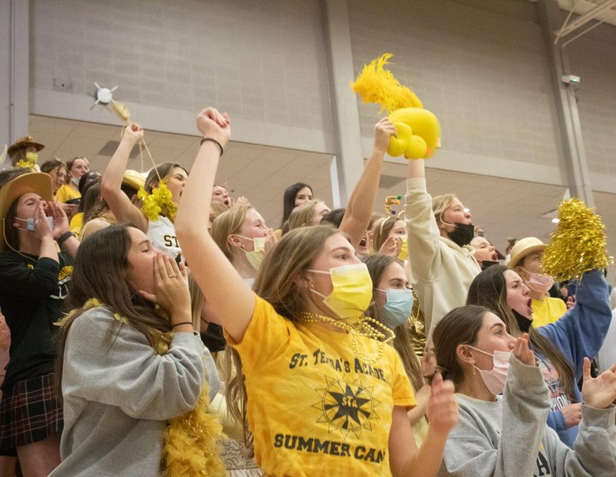 A+group+of+students+in+the+student+section+cheer+on+the+varsity+basketball+team+Feb+9.+Many+popular+STA+cheers+could+be+heard+from+the+student+section.+