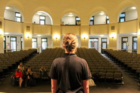 Senior Keeley Spencer stands on the edge of the stage, looking out into the auditorium Oct. 19. photo by Charlotte Malone