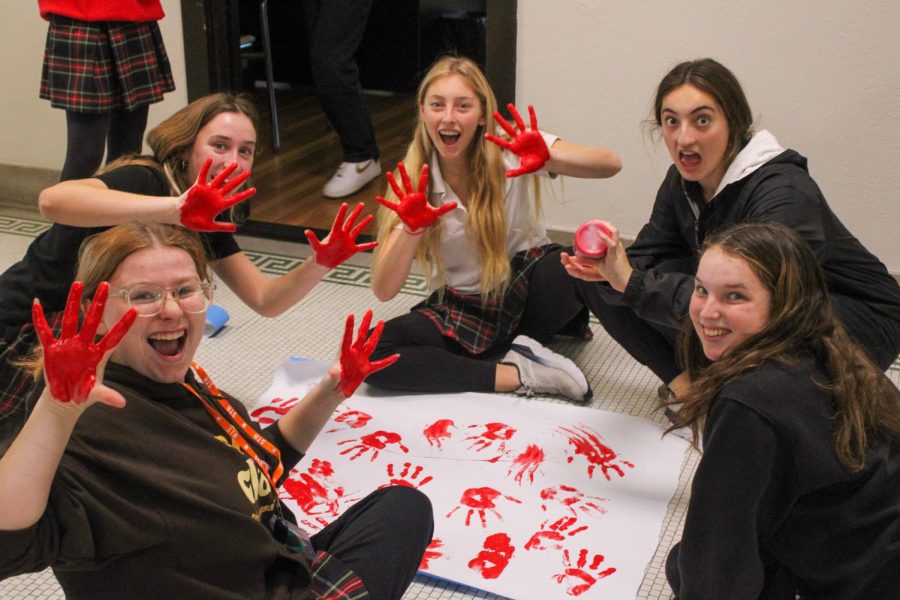 Junior Saylor Pickard, Sophomores Nina Forbes, Dossi Brender, and Sydney Graham and Senior Sophia Mock decorate their door for the Door Decorating Contest Oct. 26. photo by Jasmine Cervantes.
