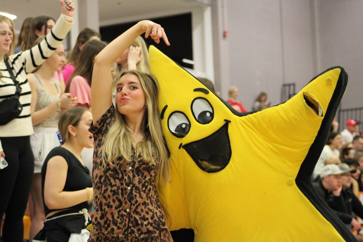 Senior Anne Rinella poses with the mascot Twinks the Star during the basketball senior night on February 6.