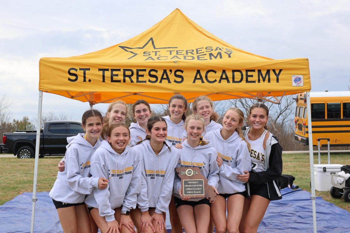 The varsity cross country team poses with their first place plaque at districts
Oct. 26.